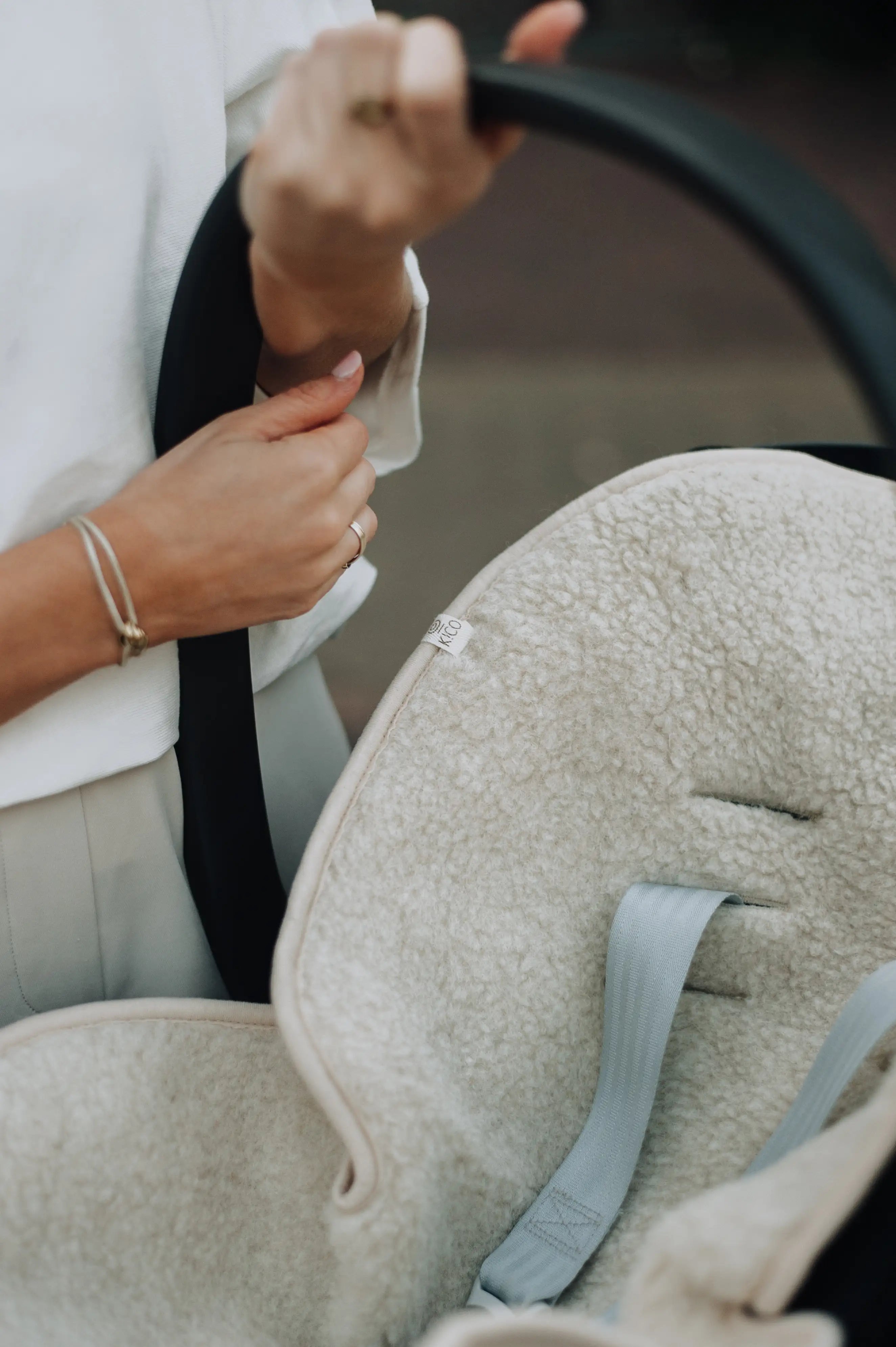 wollen onderlegger in maxi cosi met gaten voor de riempjes